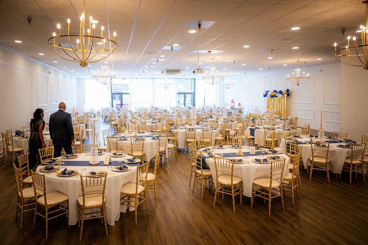Elegant banquet hall with gold chairs and chandeliers